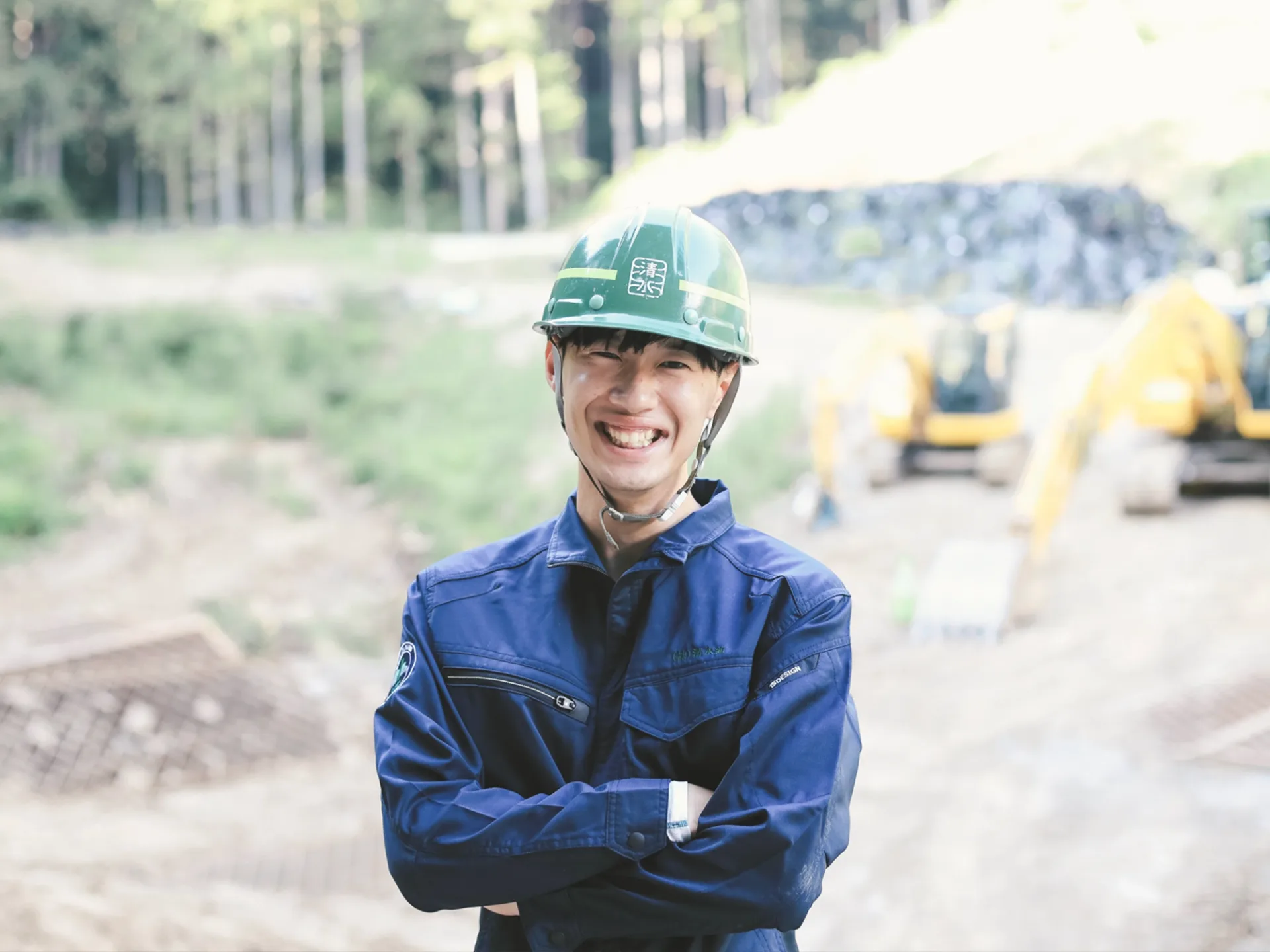 建設現場で腕を組む清水組の若手作業員